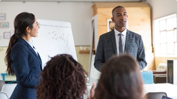 cheerful-young-speakers-standing-near-whiteboard